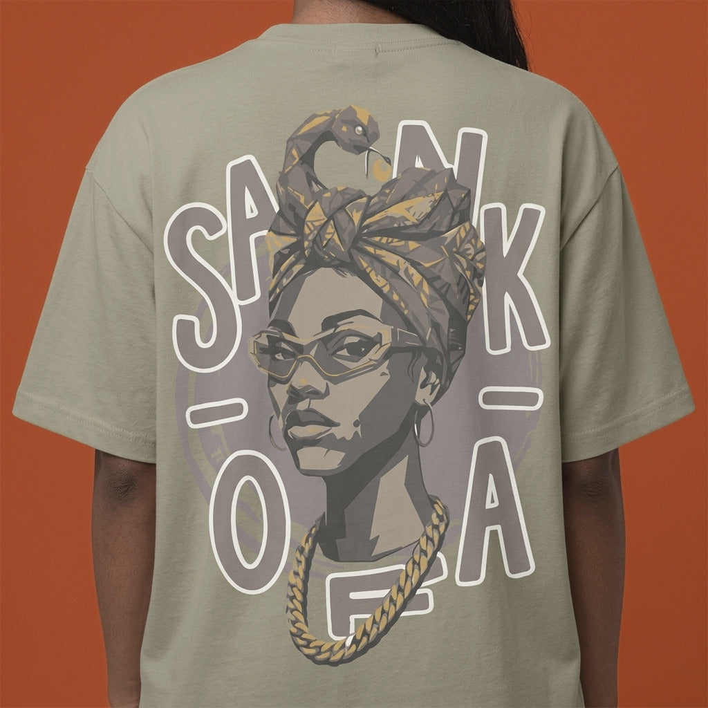 Blackness Sankofa Queen Tee, brown khaki — close-up of the Sankofa back print worn, terracotta backdrop