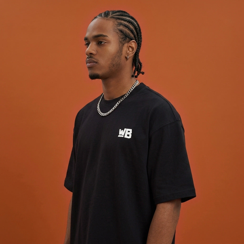 Blackness Sankofa King Tee, black — shoulder and collar detail, side view, terracotta backdrop