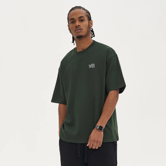 A person in front wearing the Base Blackness Tee-shirt with WB logo. - WEAREBLACKNESS.COM