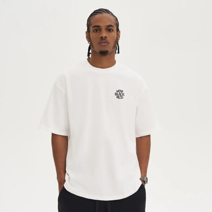 A person in front wearing the wear  Blackness Tee-shirt with print.