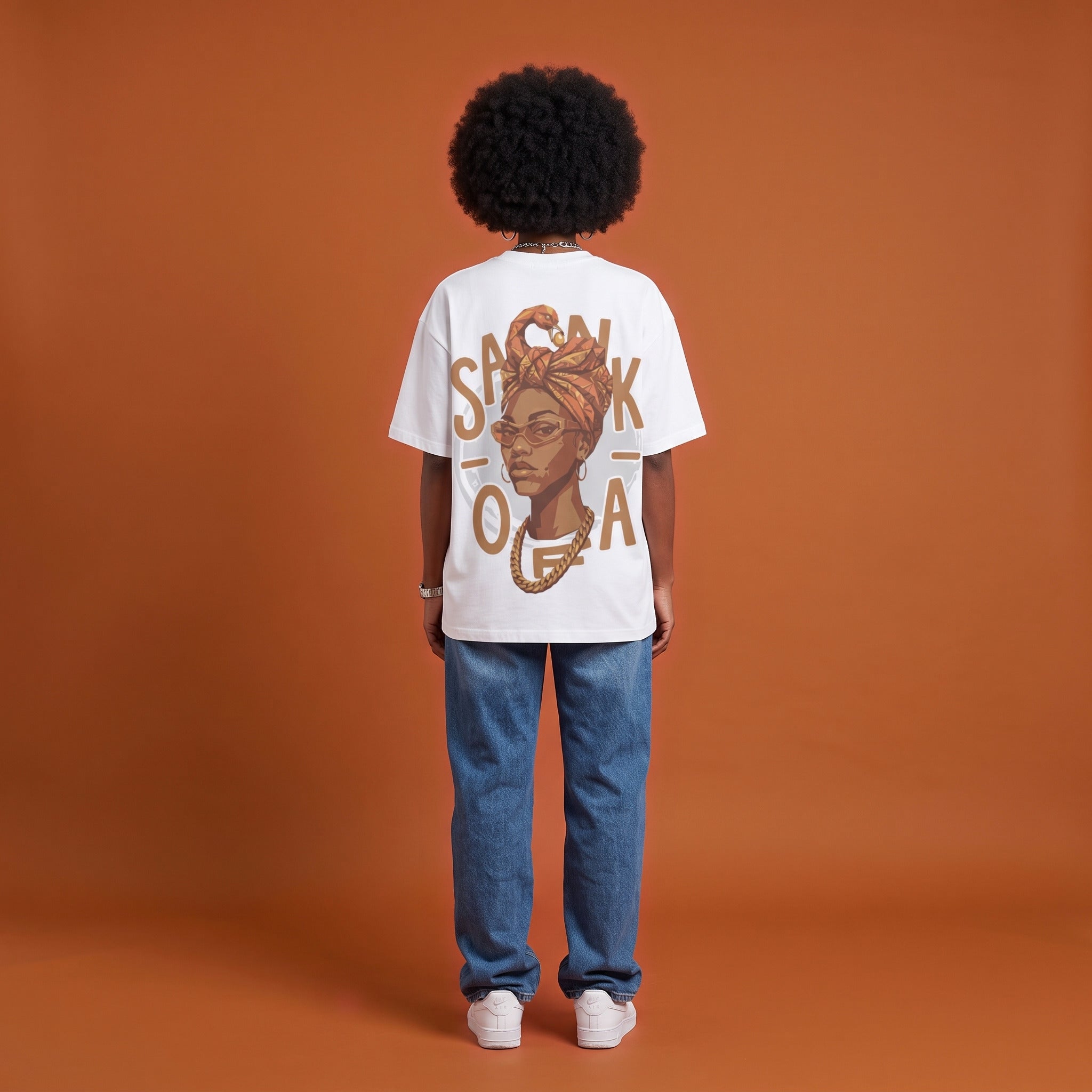Blackness Sankofa Queen Tee, white, worn by a model — back view, Sankofa headwrap portrait print, terracotta backdrop