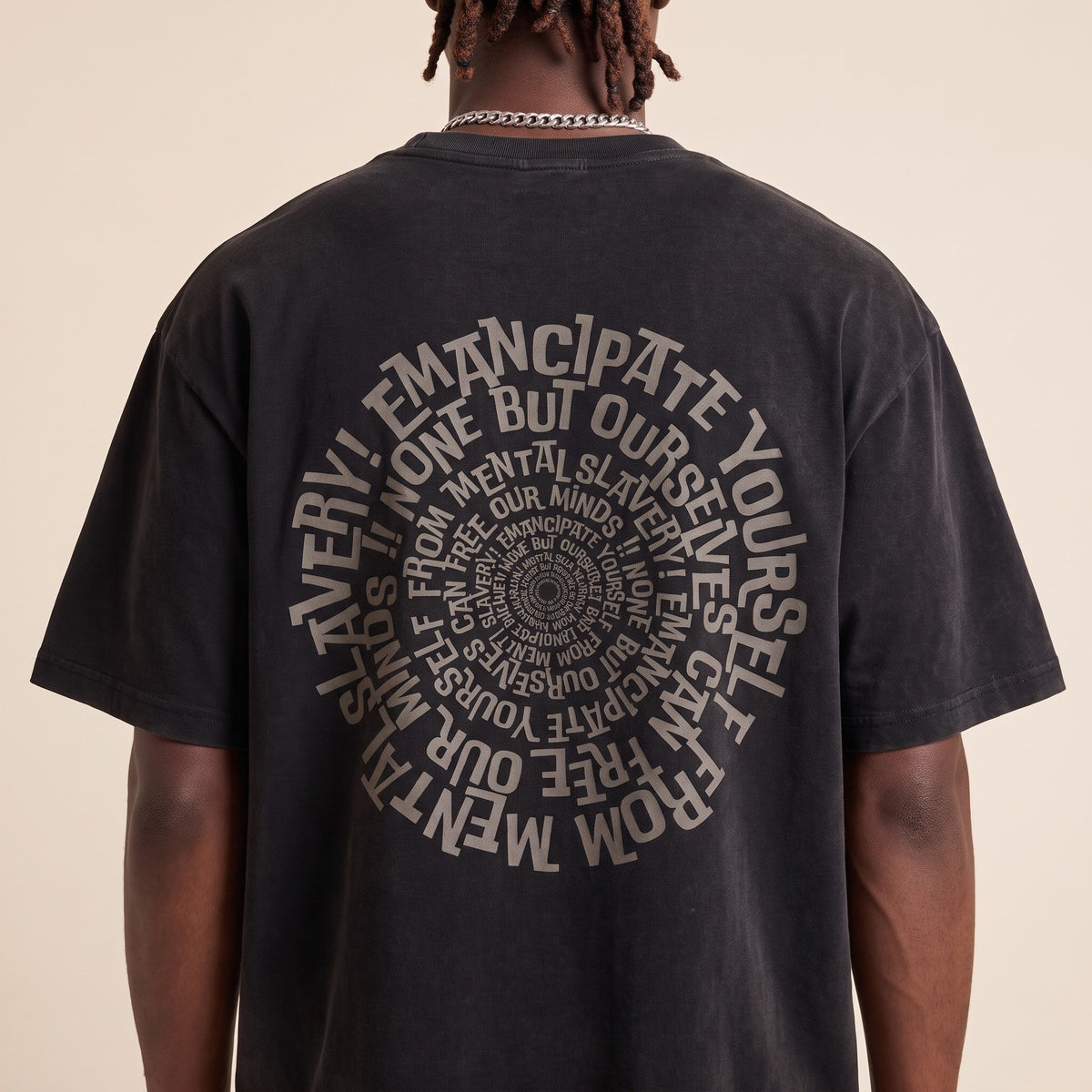 Blackness Emancipation Tee Black — close-up of the spiral Emancipate Yourself typography back print worn on the back, oversized heavyweight cotton streetwear tee by We Are Blackness