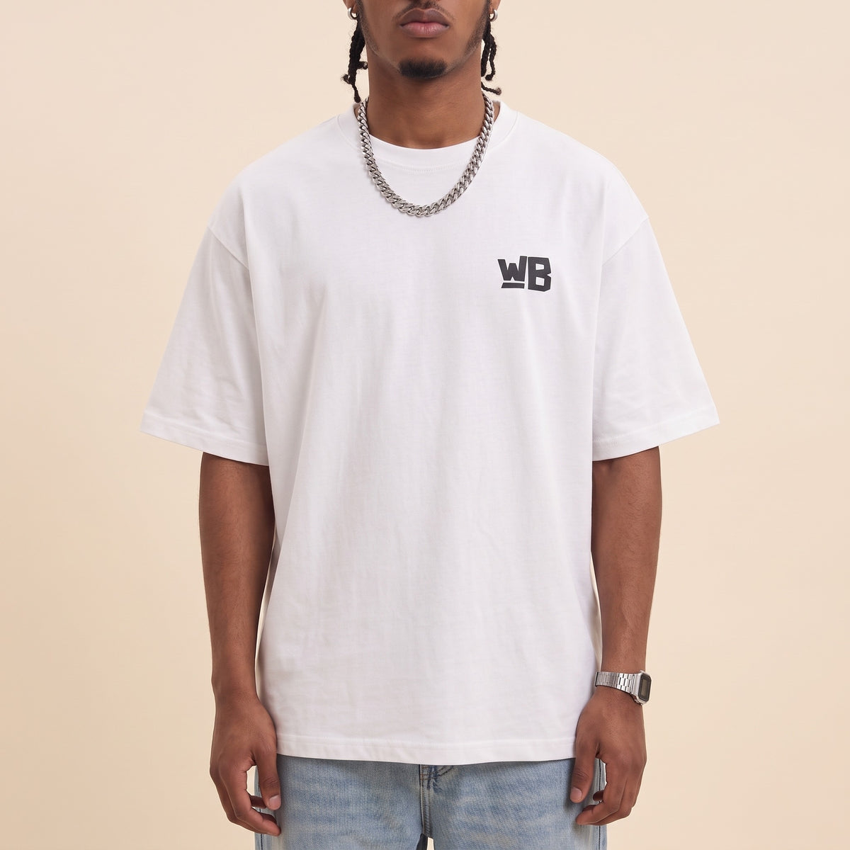 Blackness Emancipation Tee White — close-up of the WB monogram chest logo and ribbed collar, oversized heavyweight cotton streetwear tee by We Are Blackness