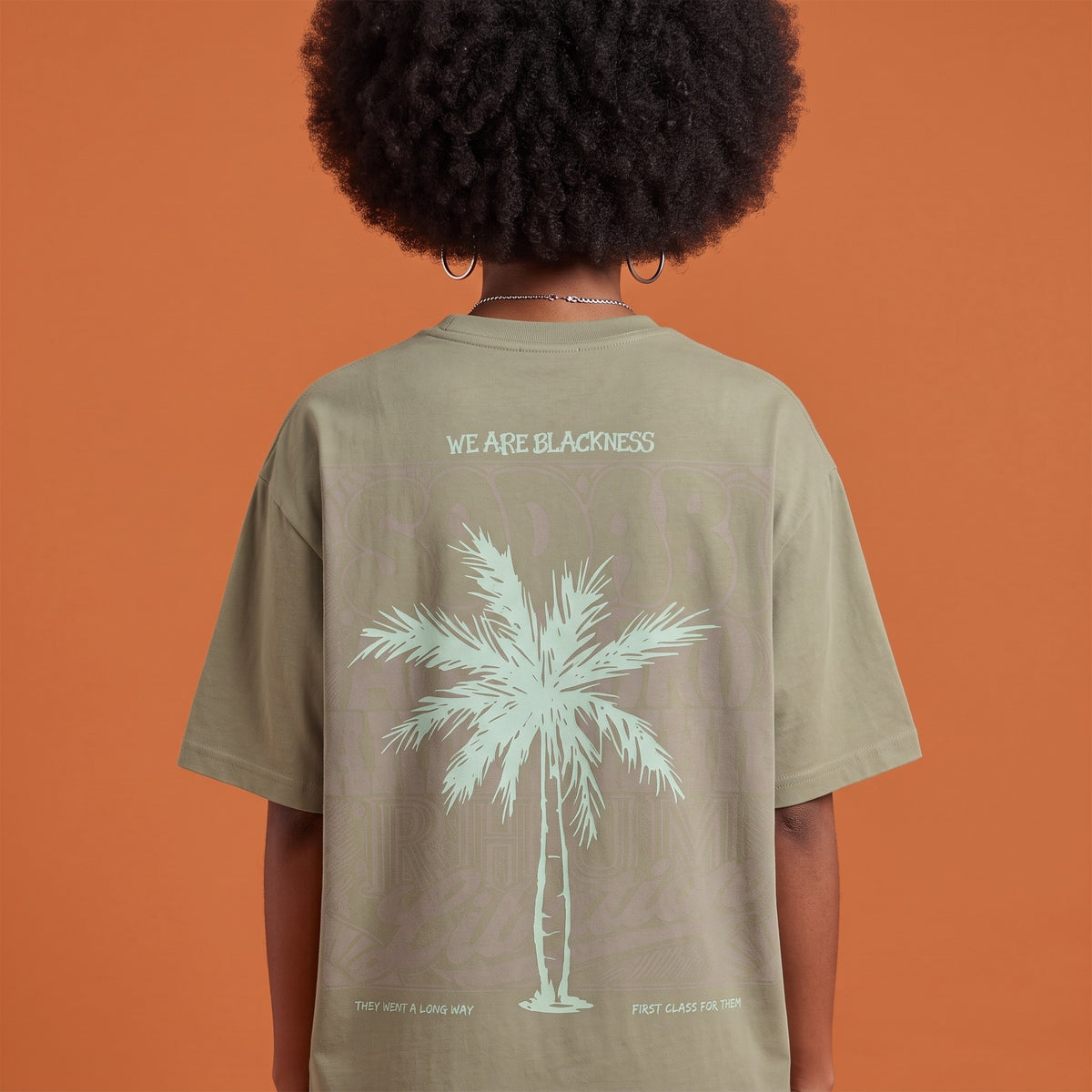 Blackness Libation Tee Brown Khaki — close-up of the palm tree Libation back print worn on the back, oversized heavyweight cotton streetwear tee by We Are Blackness