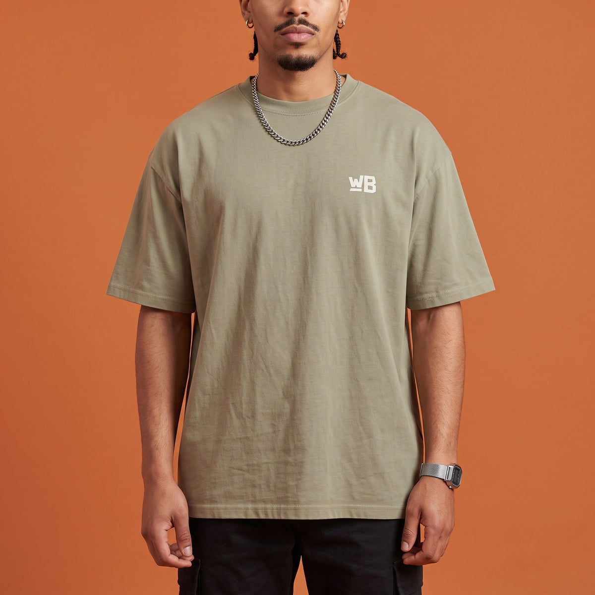 Blackness Mawon Tee Brown Khaki — close-up of the WB monogram chest logo and ribbed collar, oversized heavyweight cotton streetwear tee by We Are Blackness