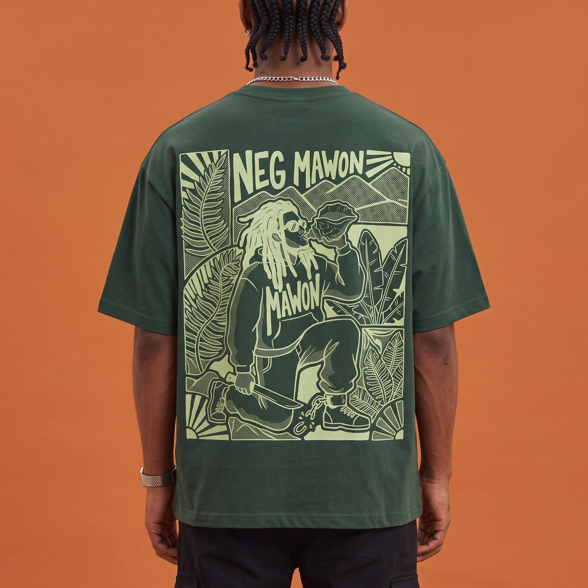 Blackness Mawon Tee Forest Green — close-up of the Neg Mawon conch-blower linocut back print worn on the back, oversized heavyweight cotton streetwear tee by We Are Blackness