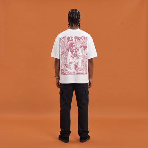 Blackness Mawon Tee, white, worn by a model — back view, Neg Mawon conch-blower block print, terracotta-orange studio backdrop