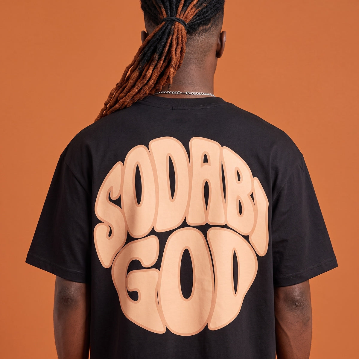Blackness Sodabi Tee Black — close-up of the SODABI GOD bubble-letter back print worn on the back, oversized heavyweight cotton streetwear tee by We Are Blackness