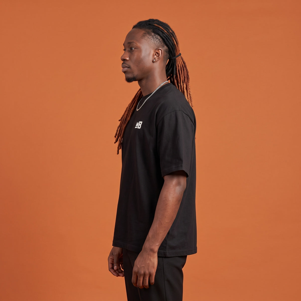 Blackness Sodabi Tee Black — side view of the drop-shoulder sleeve and boxy oversized fit, oversized heavyweight cotton streetwear tee by We Are Blackness