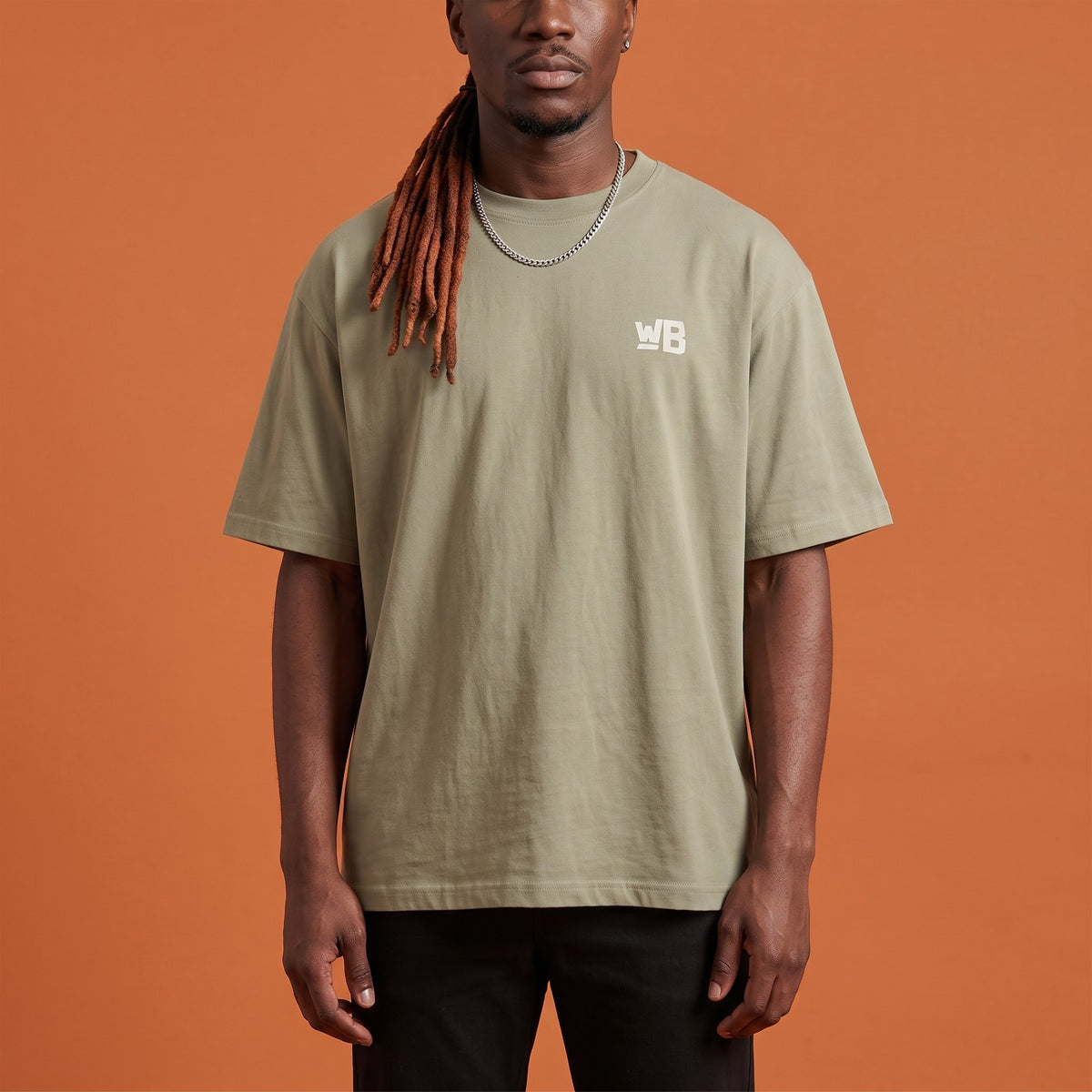 Blackness Sodabi Tee Brown Khaki — close-up of the WB monogram chest logo and ribbed collar, oversized heavyweight cotton streetwear tee by We Are Blackness