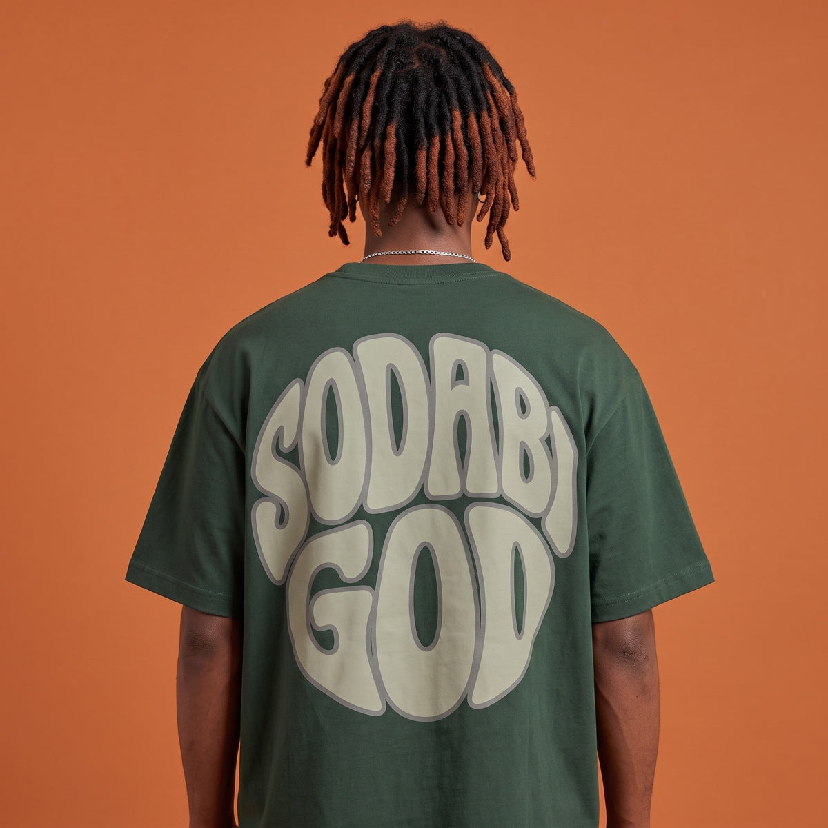 Blackness Sodabi Tee Forest Green — close-up of the SODABI GOD bubble-letter back print worn on the back, oversized heavyweight cotton streetwear tee by We Are Blackness