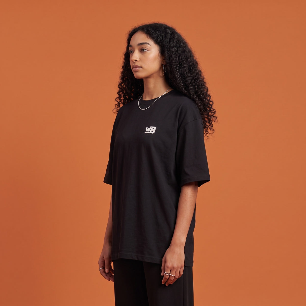 Blackness Solitude Tee Black — side view of the drop-shoulder sleeve and boxy oversized fit, oversized heavyweight cotton streetwear tee by We Are Blackness