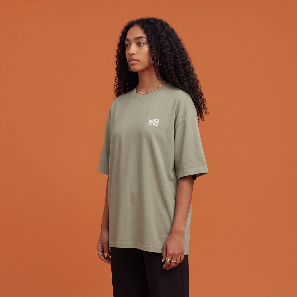 Blackness Solitude Tee Brown Khaki — side view of the drop-shoulder sleeve and boxy oversized fit, oversized heavyweight cotton streetwear tee by We Are Blackness