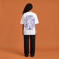 Blackness Solitude Tee, white, worn by a model — back view, Solitude portrait block print, terracotta-orange studio backdrop