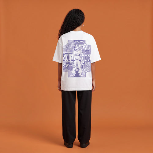 Blackness Solitude Tee, white, worn by a model — back view, Solitude portrait block print, terracotta-orange studio backdrop