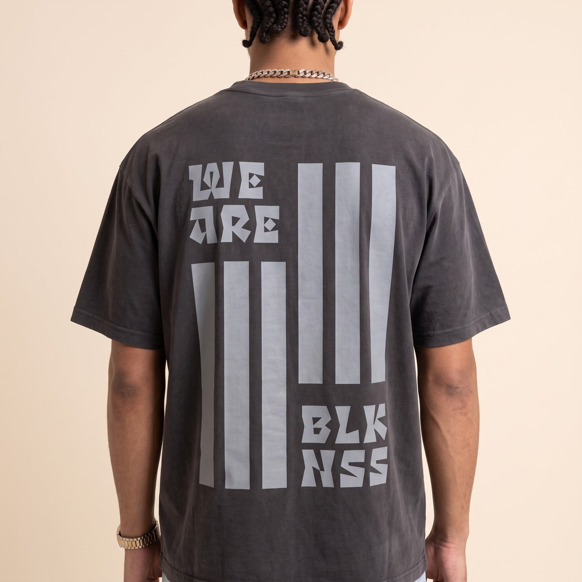 Blackness WABLKNSS Tee Black — close-up of the We Are BLK NSS stripe graphic back print worn on the back, oversized heavyweight cotton streetwear tee by We Are Blackness