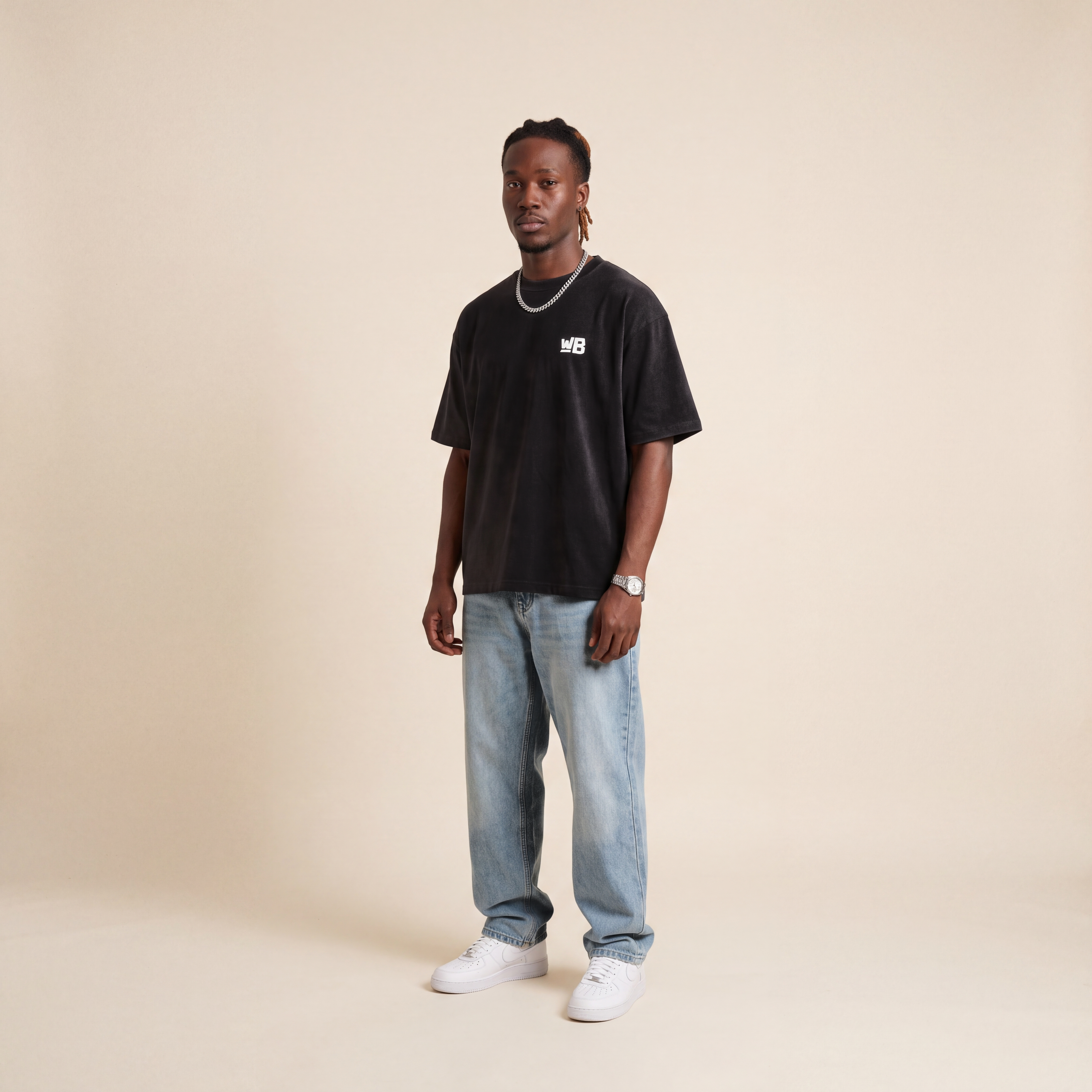 Blackness Emancipation Tee Black worn by model, front view with WB chest logo on beige studio backdrop