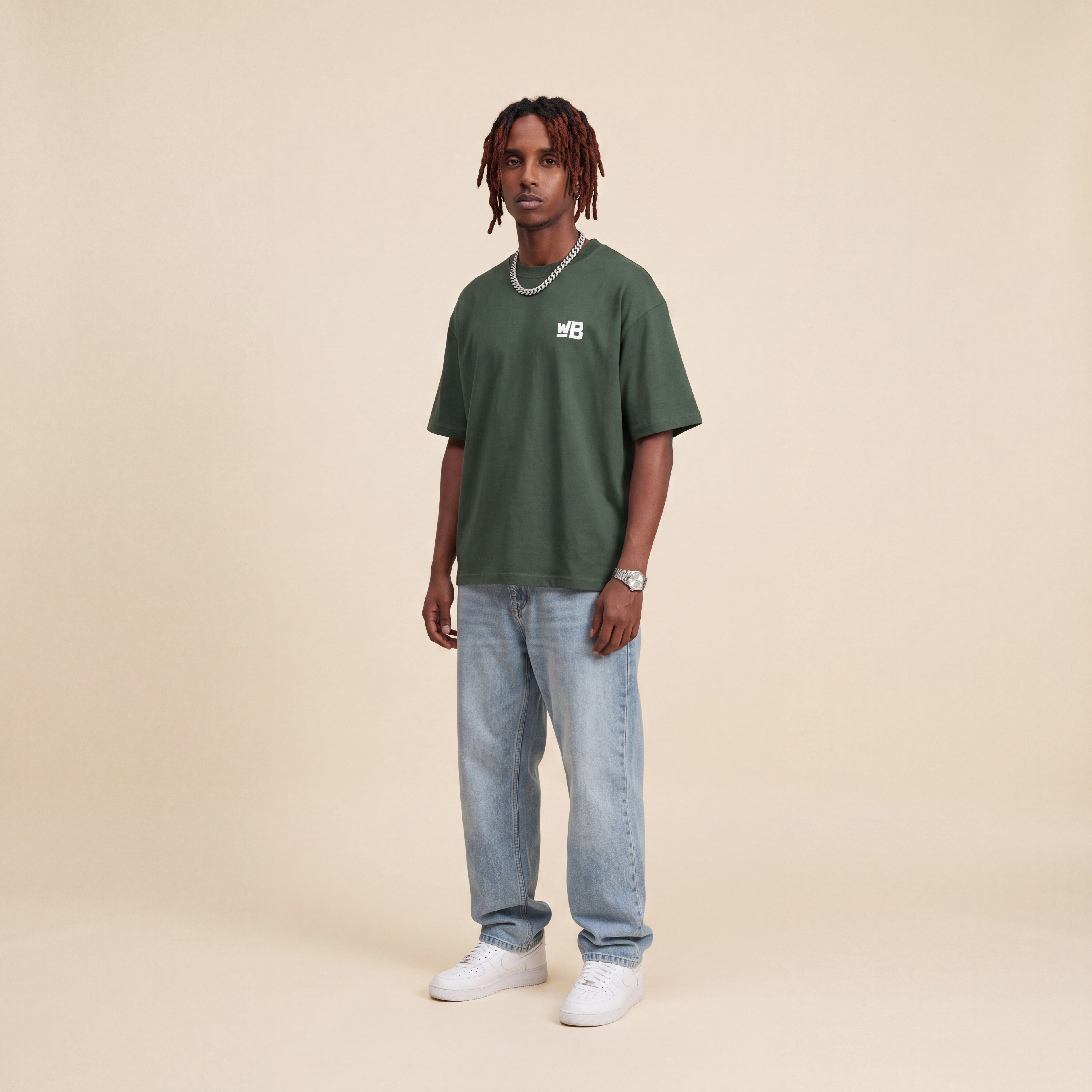 Blackness Emancipation Tee Cactus Green worn by model, front view with WB chest logo on beige studio backdrop