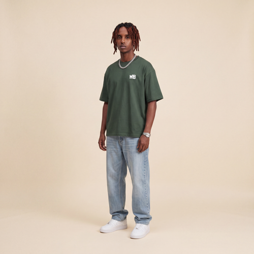 Blackness Emancipation Tee Cactus Green worn by model, front view with WB chest logo on beige studio backdrop