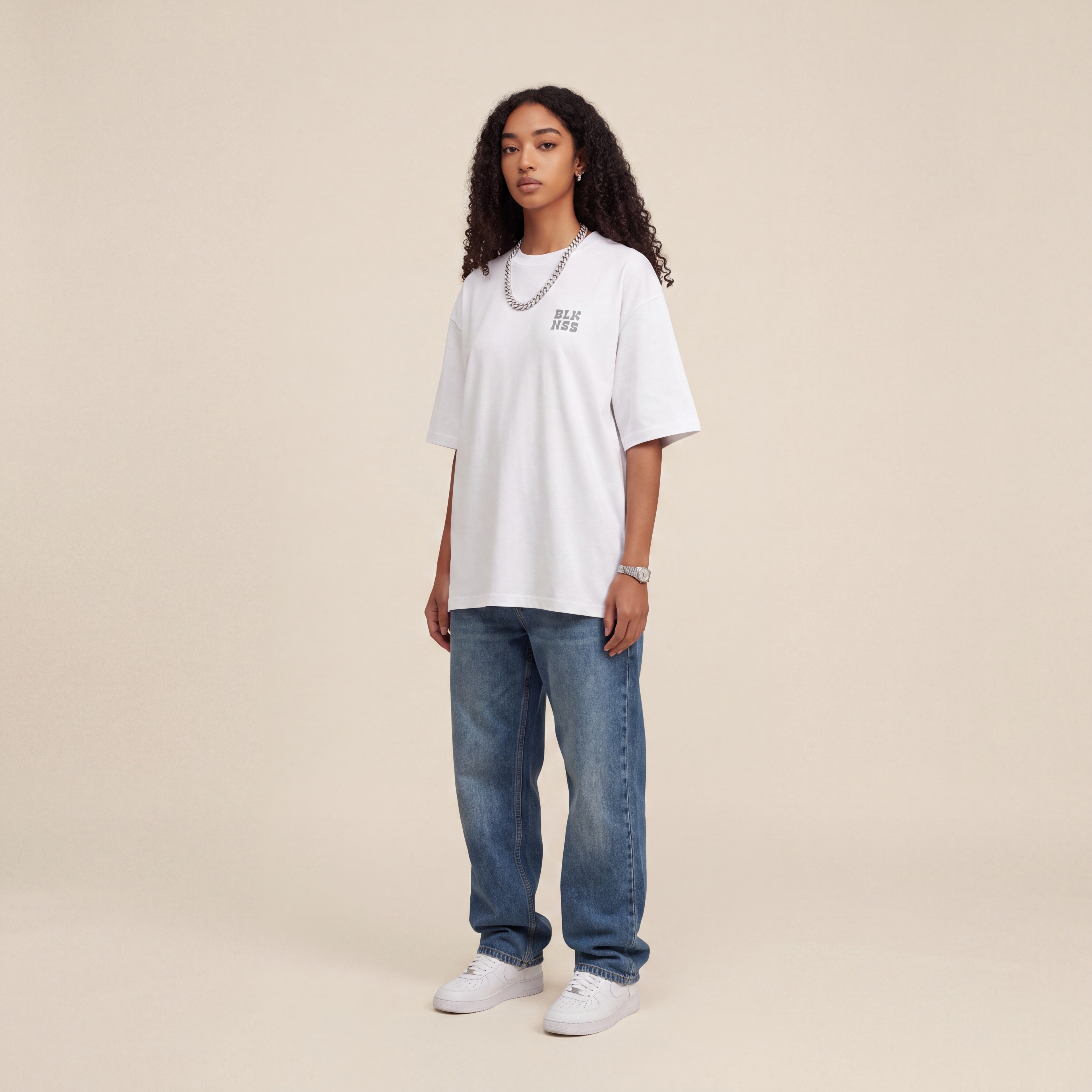 Blackness WABLKNSS Tee White worn by model, front view on beige studio backdrop