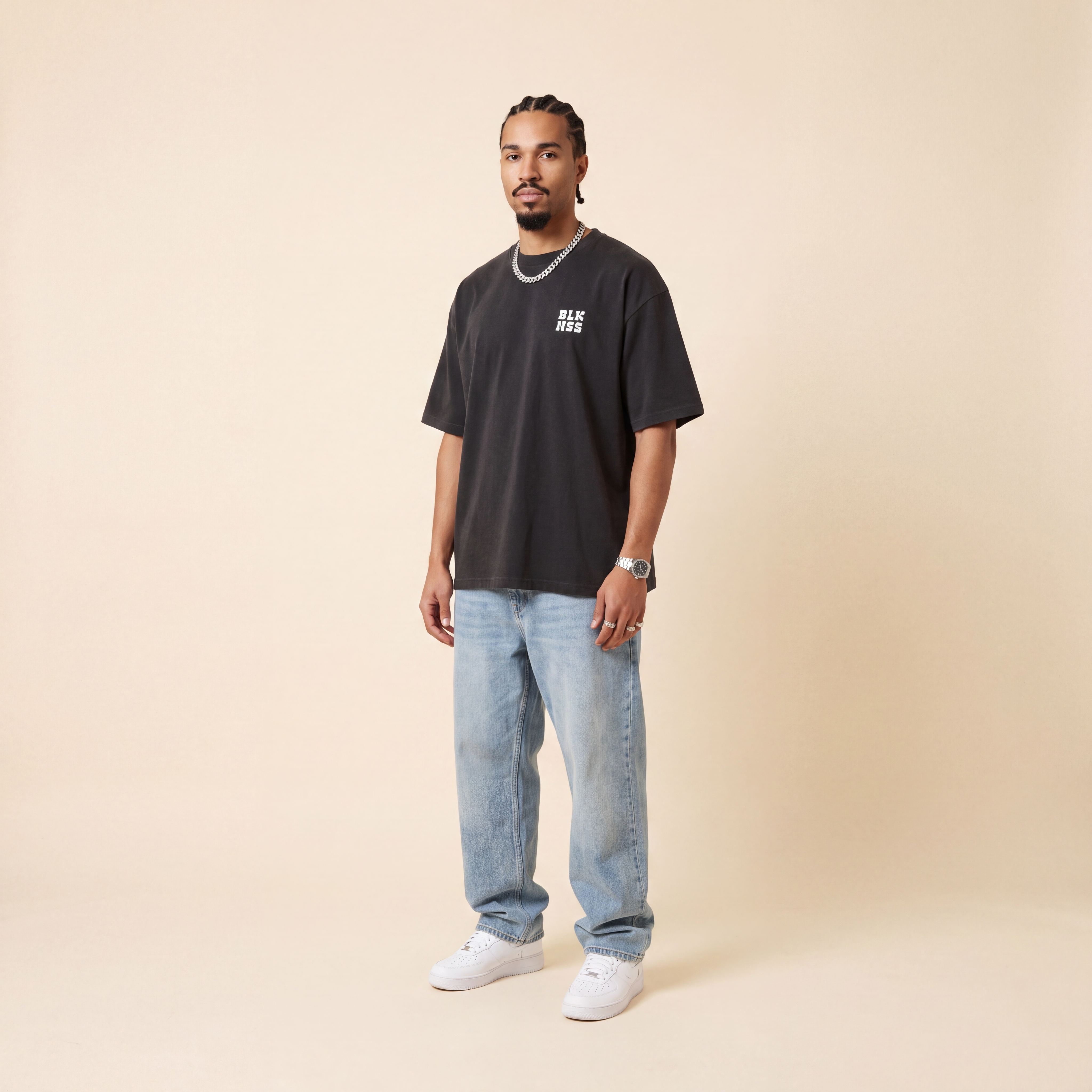 Blackness WABLKNSS Tee Black worn by model, front view on beige studio backdrop