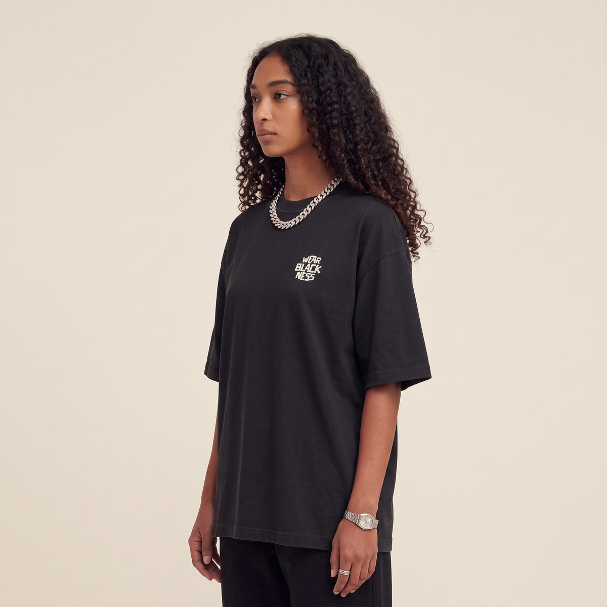 Wear Blackness Tee Black — side view of the drop-shoulder sleeve and boxy oversized fit, oversized heavyweight cotton streetwear tee by We Are Blackness